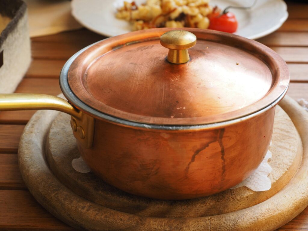 Brown Lidded Cooking Pot on Gray Round Wooden Coaster