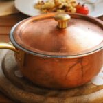 Brown Lidded Cooking Pot on Gray Round Wooden Coaster