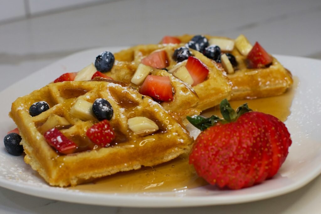 a plate of waffles with fruit on top